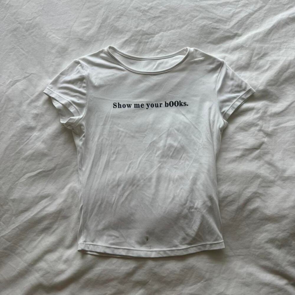 White baby tee with "show me your books" print